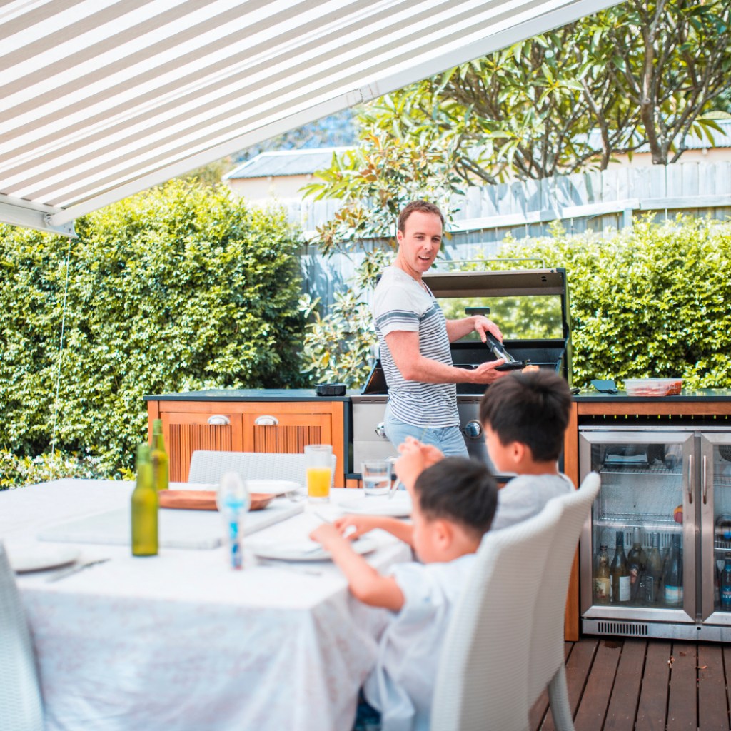 Dad and kids in covered outdoor kitchen area