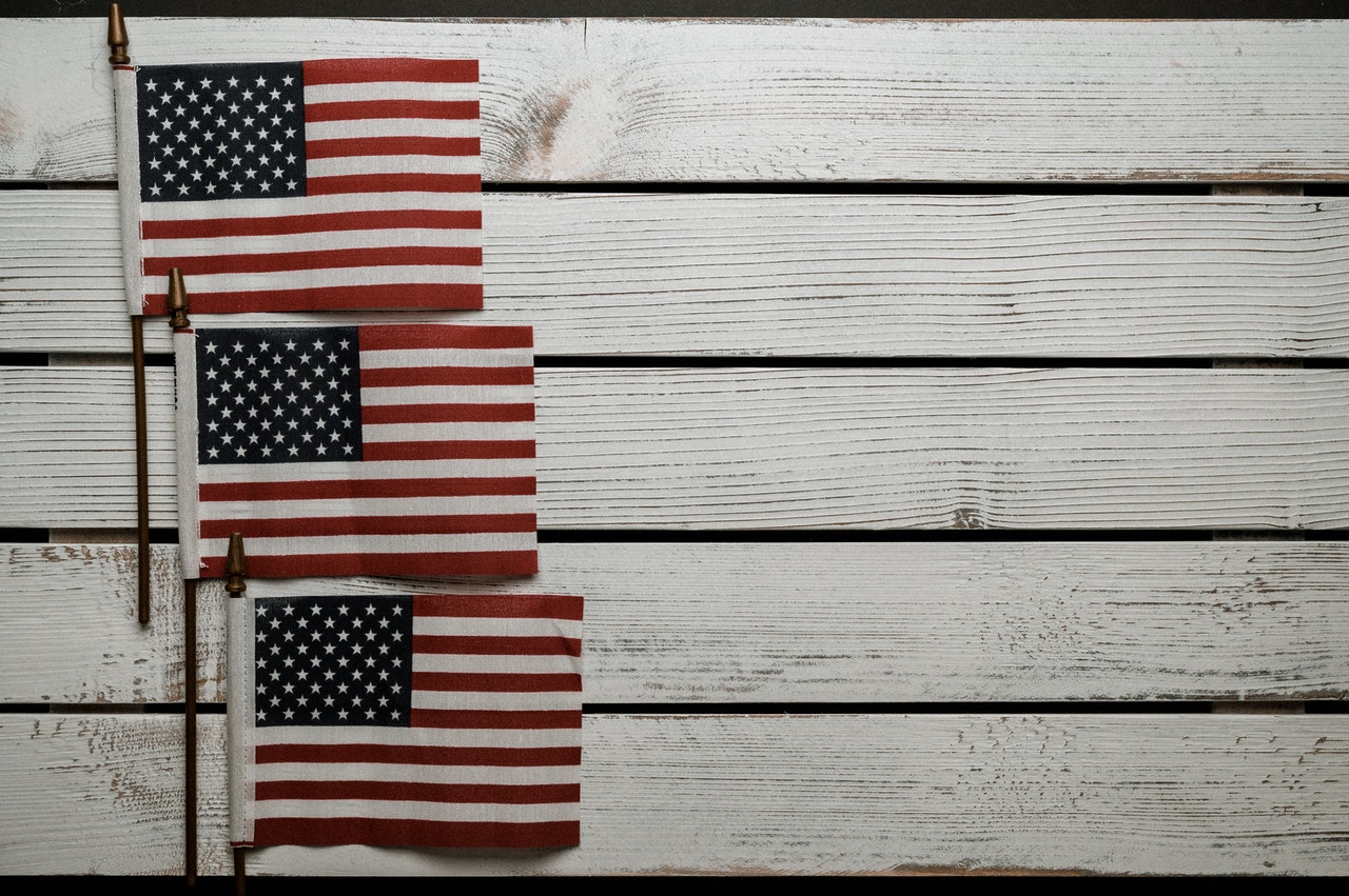 Three American flags on whitewashed wood