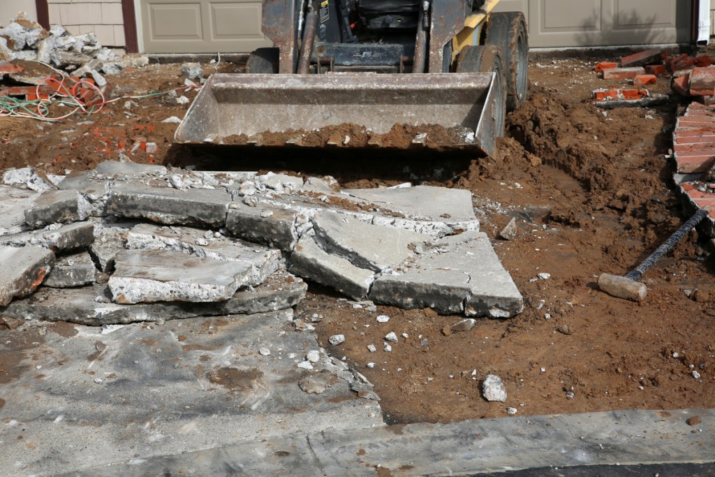 skid loader removing broken concrete slabs