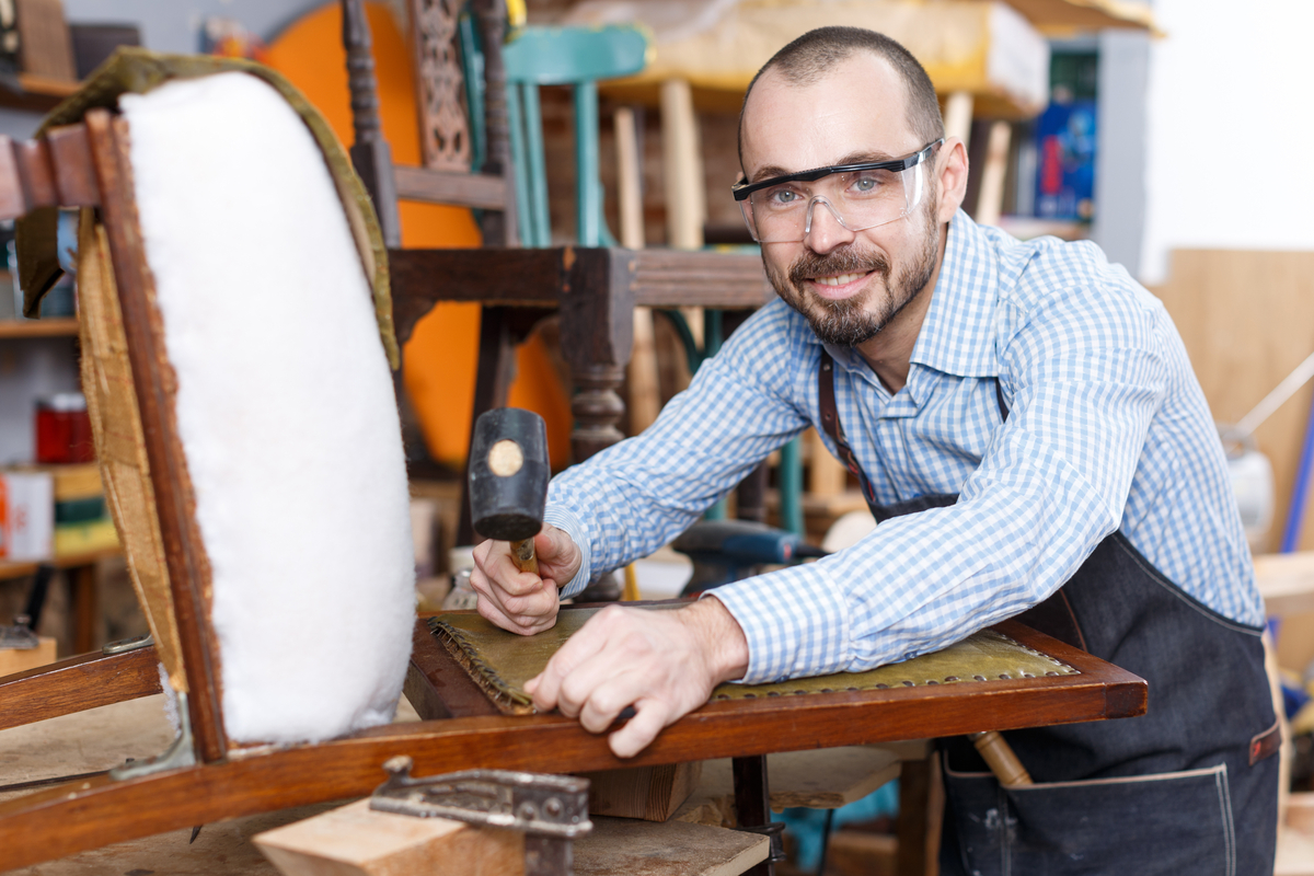 man reupholstering a chair