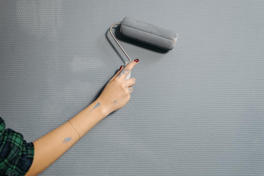 Female hand painting wall