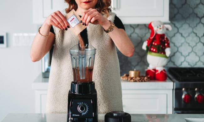 soman with blender in kitchen