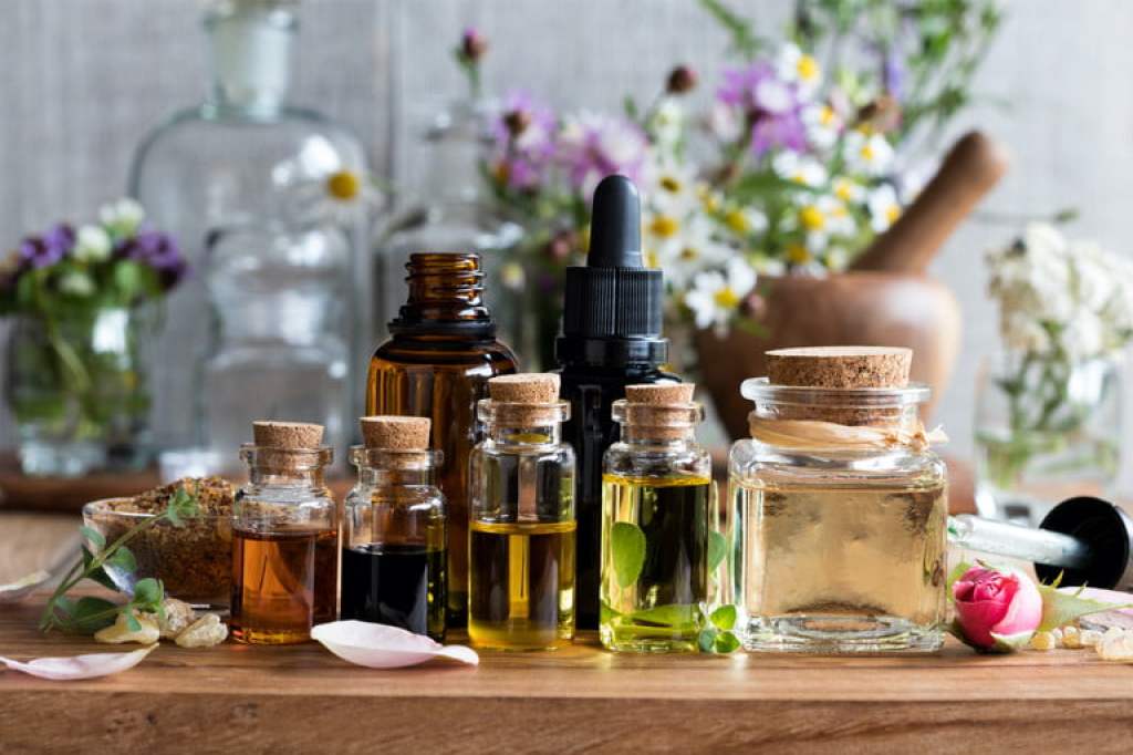 essential oils in small jars with flower decor