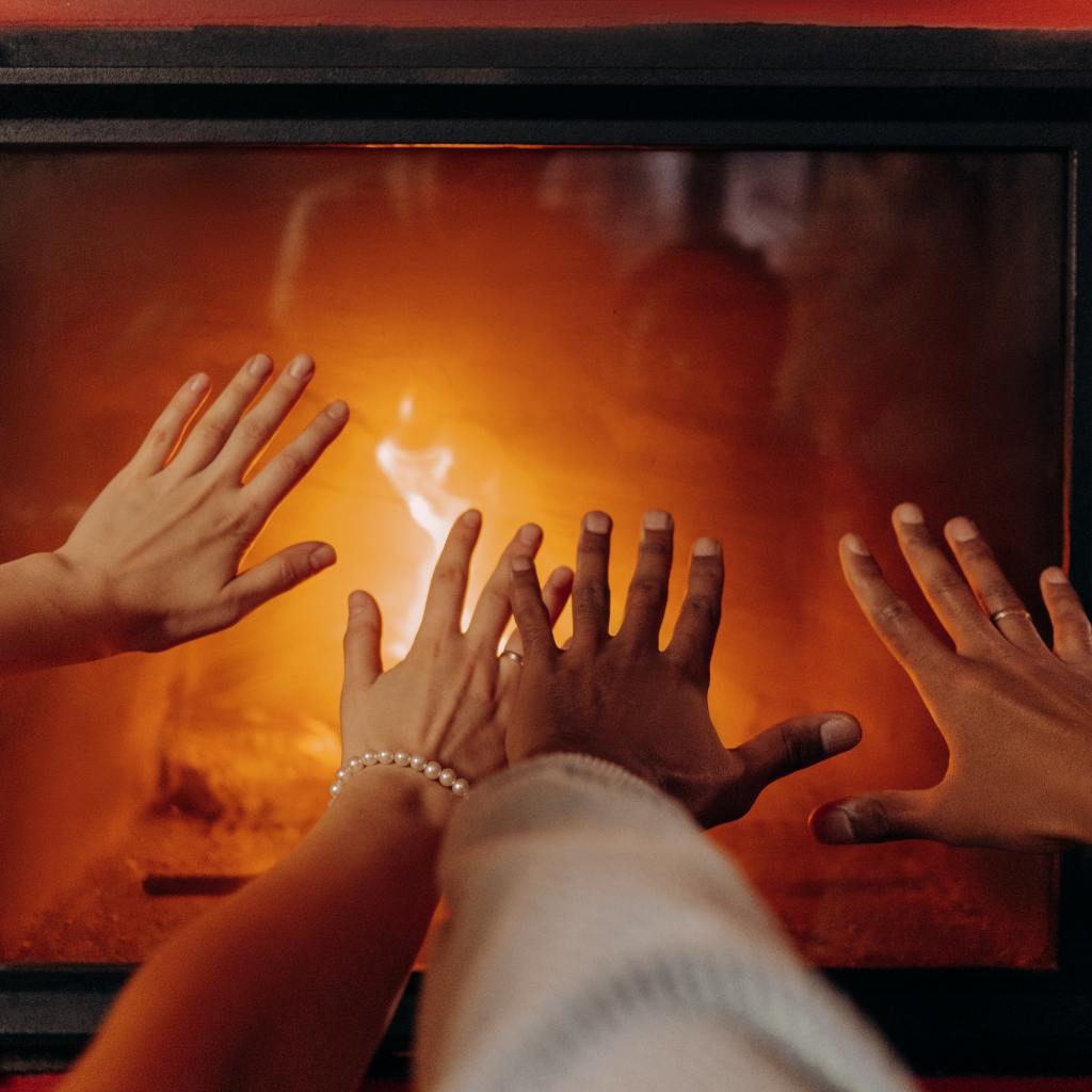 Hands reaching out toward fake fireplace