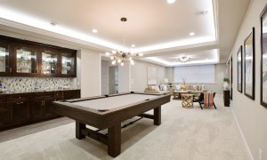 Finished basement with pool table and light colored walls
