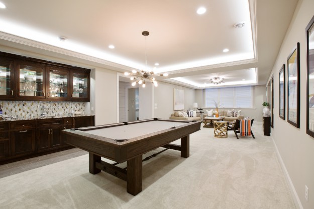 Finished basement with pool table and light colored walls