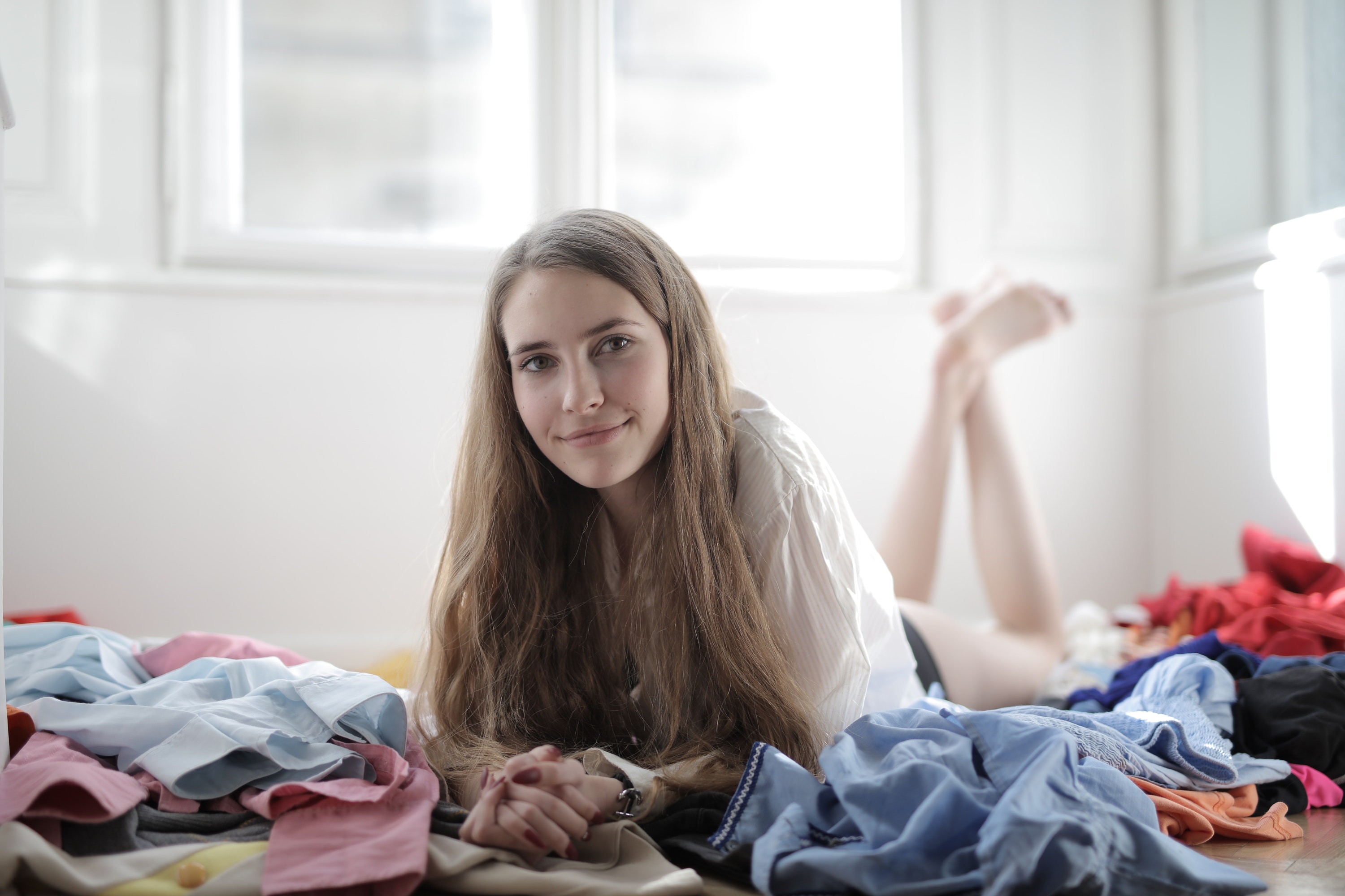 Girl surrounded by clutter on bed