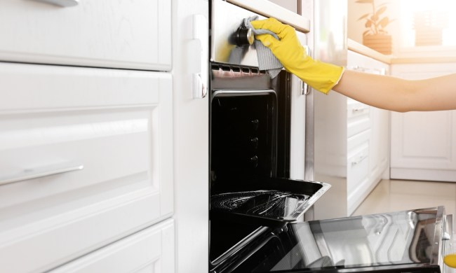 Gloved hand cleaning an oven