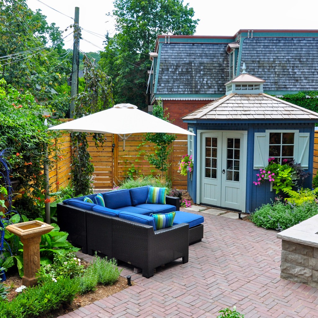 Backyard patio with pavers, plants, and furniture