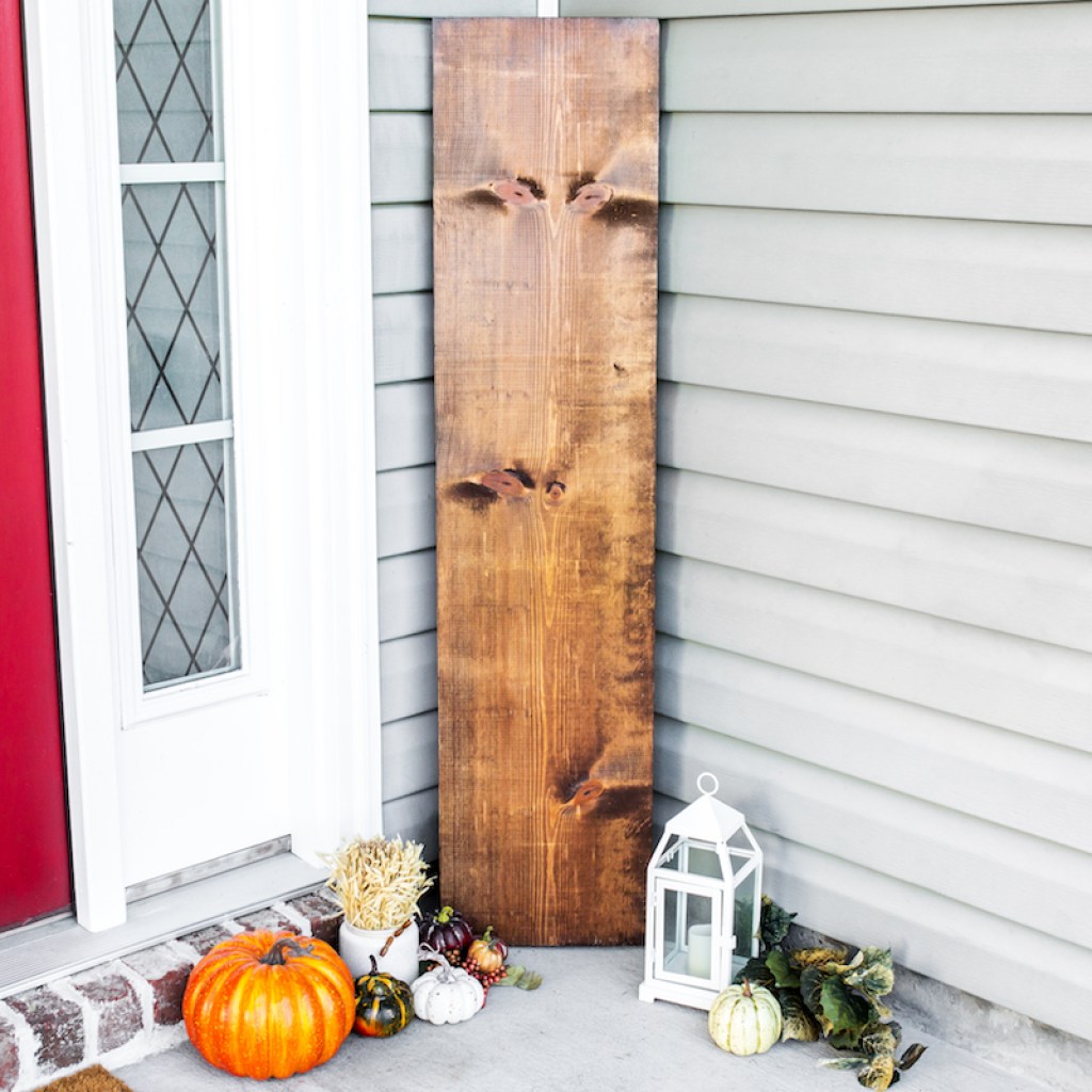 fall wood sign by front door with pumpkins