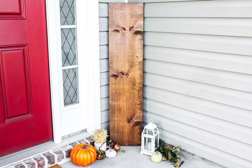 fall wood sign by front door with pumpkins