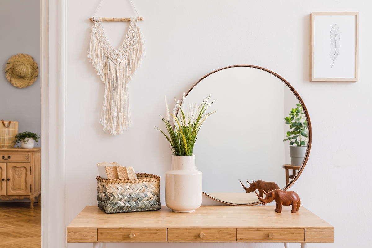 Mirror and green plant on an entryway table