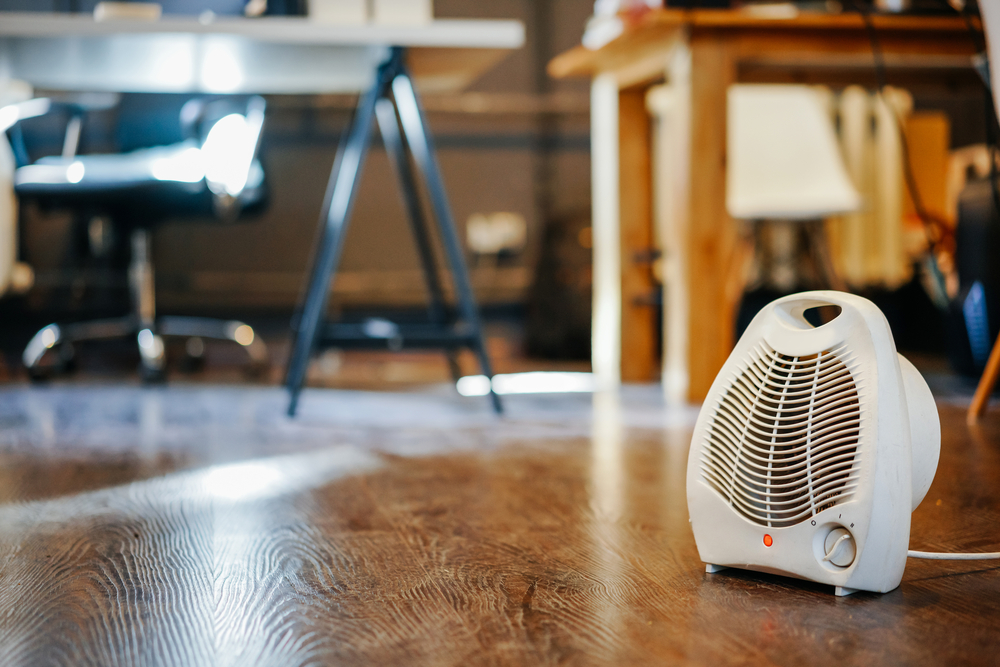 White space heater on a hardwood floor in an office