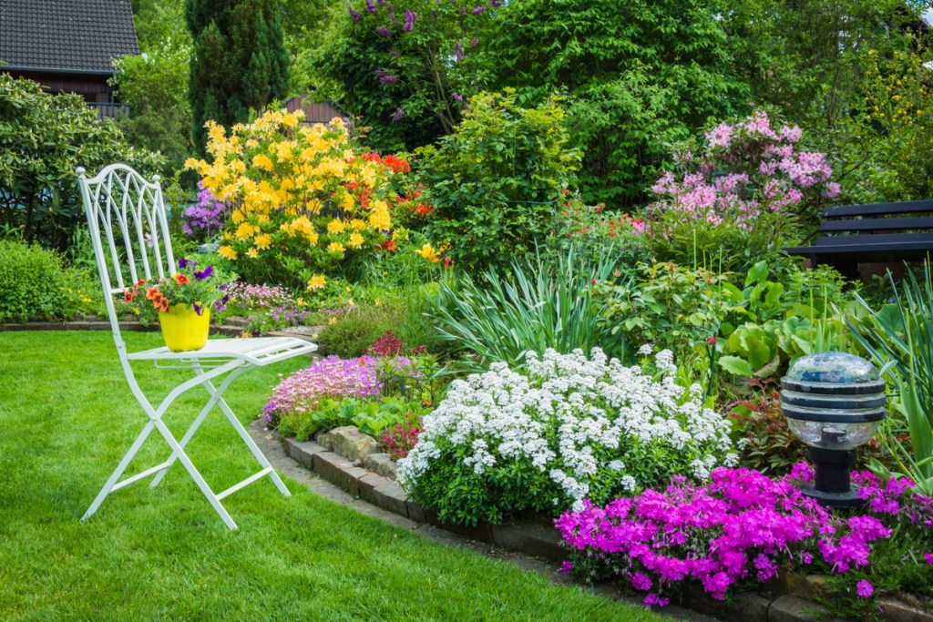 Chair beside blooming flower garden