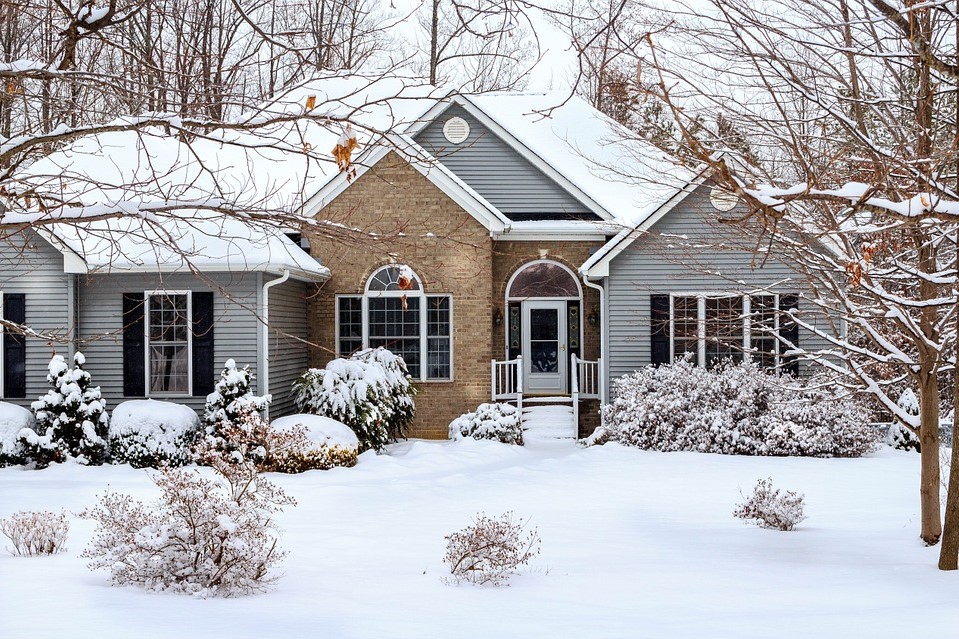 house with vinyl siding and brick in winter