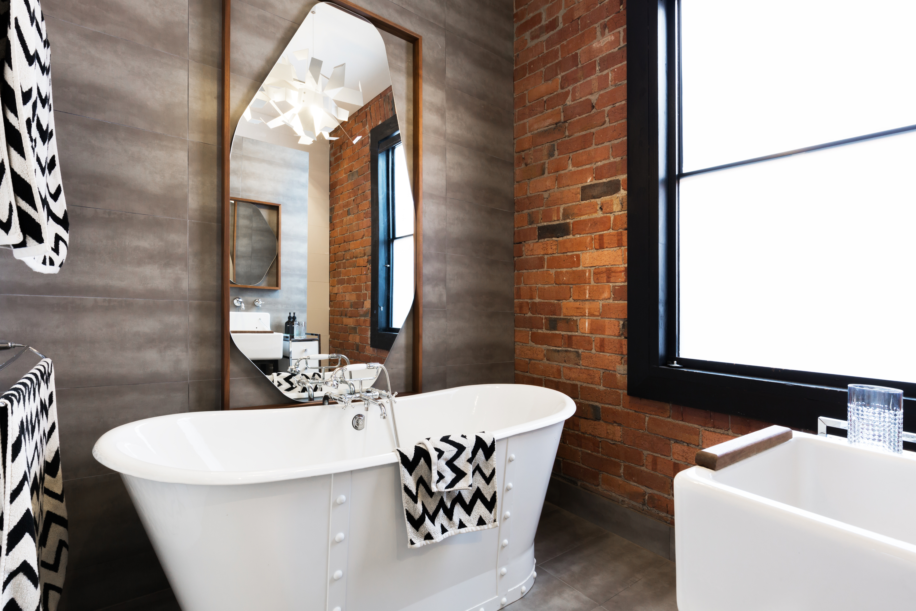 bathroom with tile and brick wall