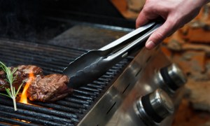 Using tongs on a gas grill
