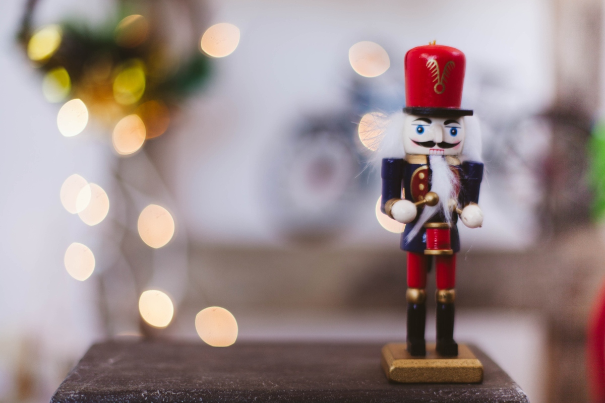 christmas nutcracker sitting on table with lights in the background