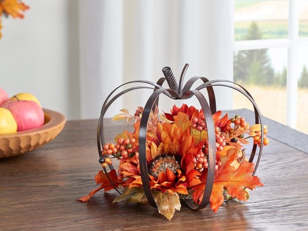 Metal pumpkin frame with floral arrangement centerpiece.