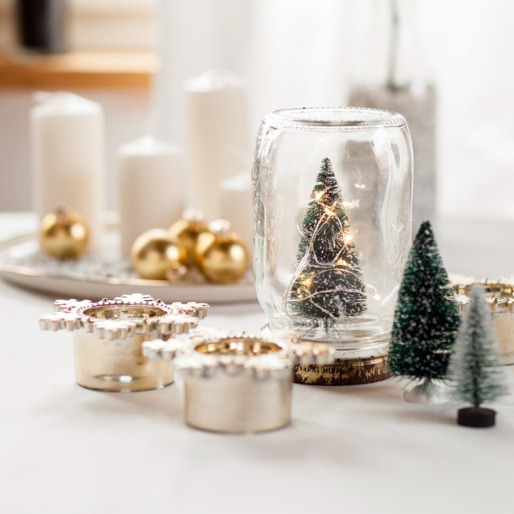 Modern christmas decorations with candles, bulbs, and small trees.