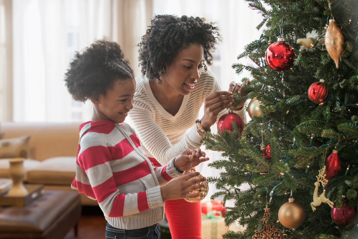 a mother and daughter decorate a christmas tree together