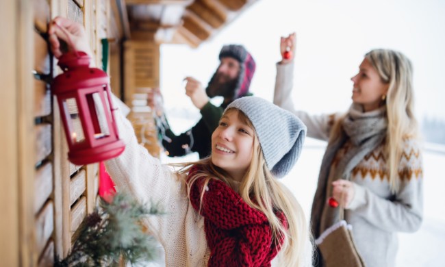 Family decorating the outside of their home for the holidays
