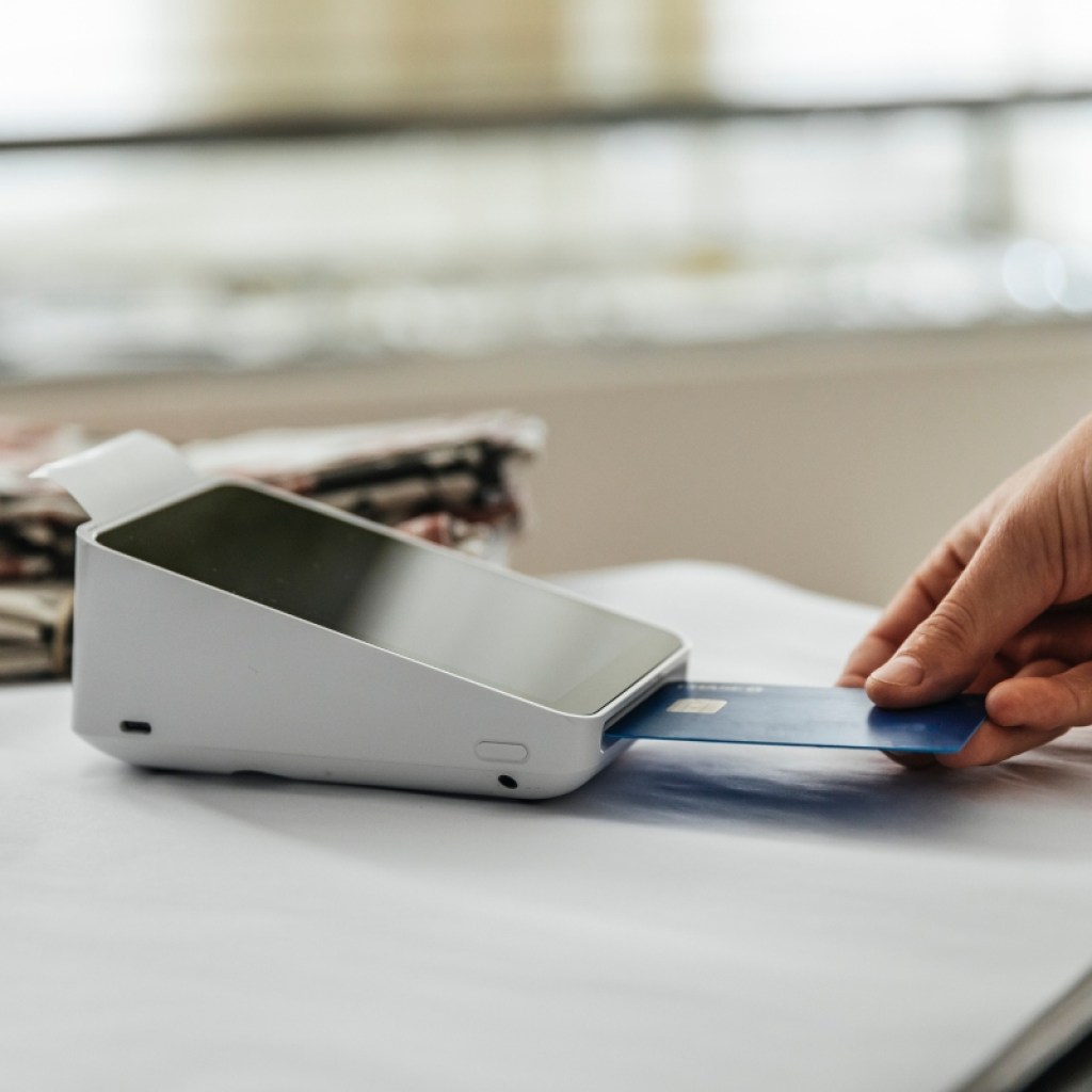 person using a credit card at a store card reader