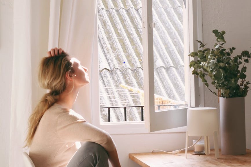 woman sitting at table – window – plant