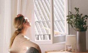 Woman sitting at a table by a window