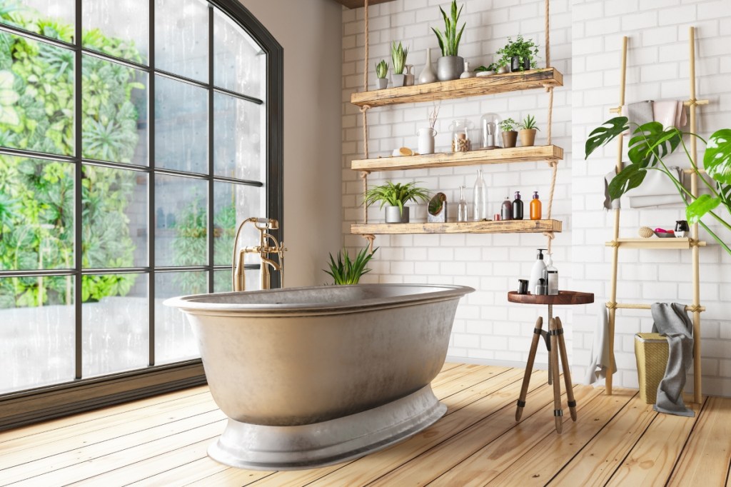 Plants and large window in modern bathroom with large tub