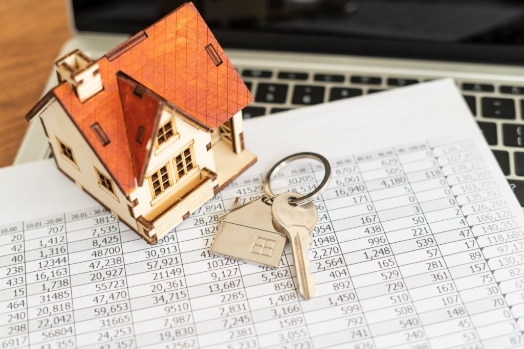 Small home on mortgage papers beside house keys