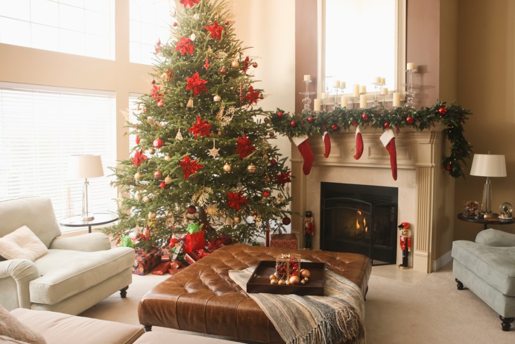Traditional styled Christmas decor on fireplace mantle with tree