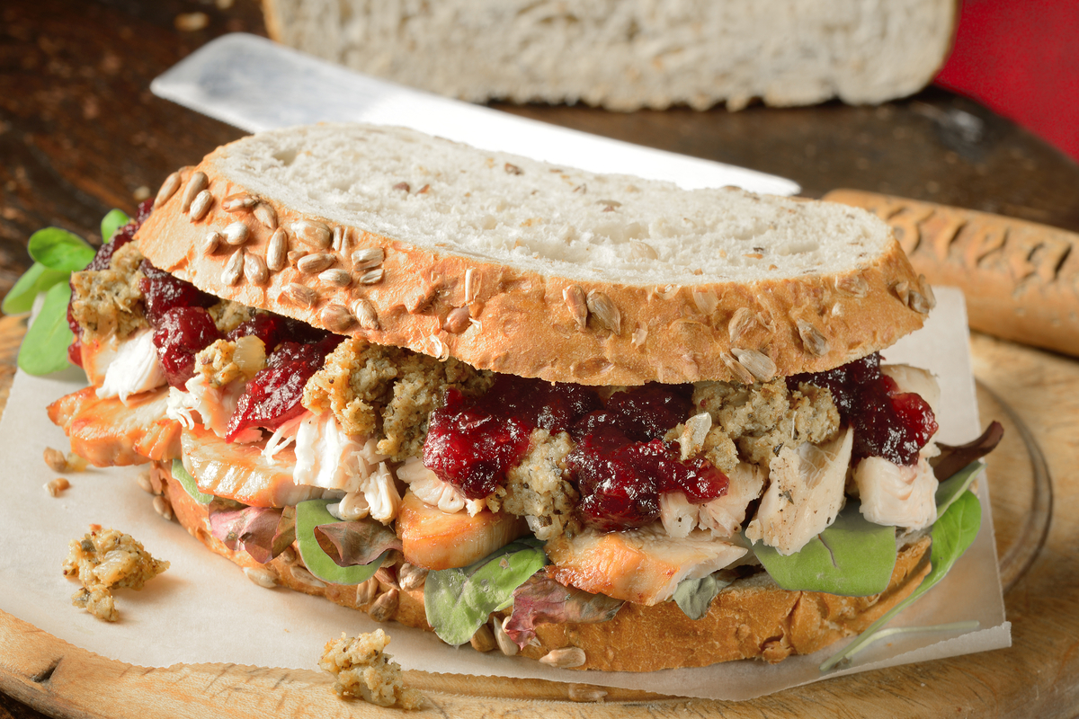 Leftovers sandwich made of turkey, cranberry sauce, stuffing, and lettuce.