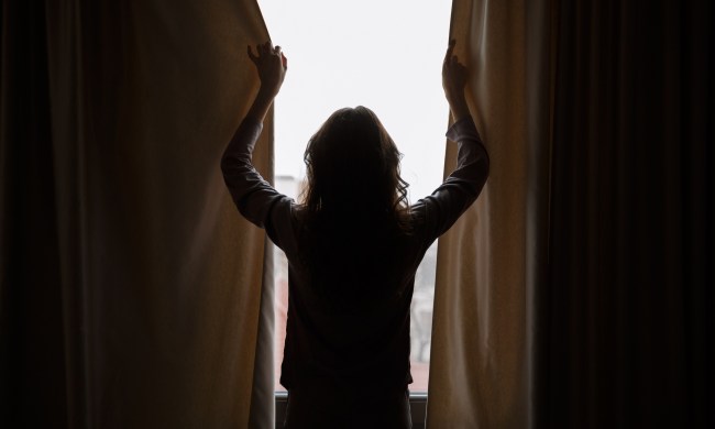 Woman closing blackout curtains