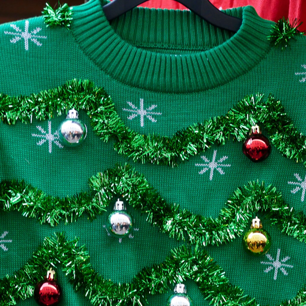 Green ugly Christmas sweater on hanger