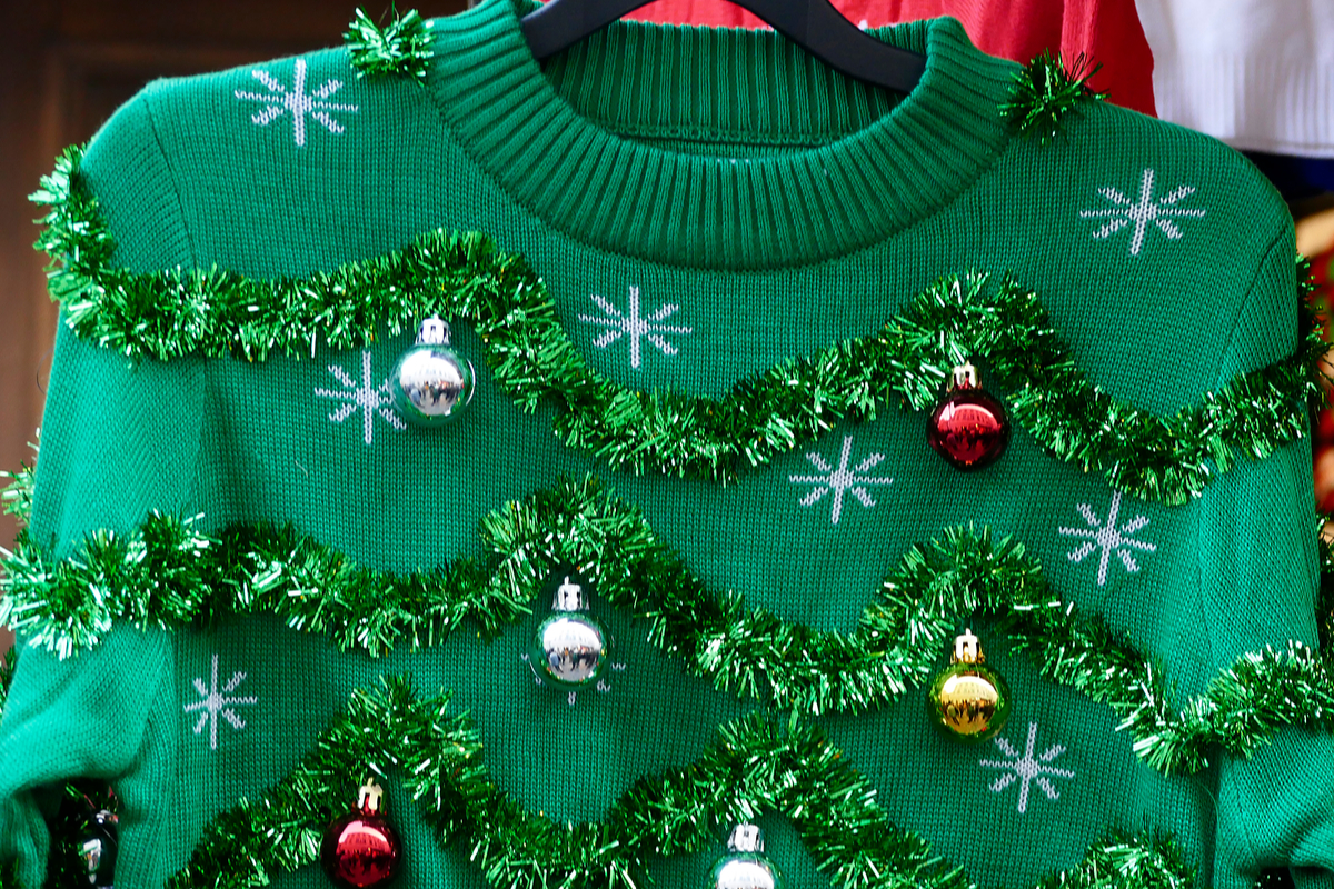 Green ugly Christmas sweater on hanger
