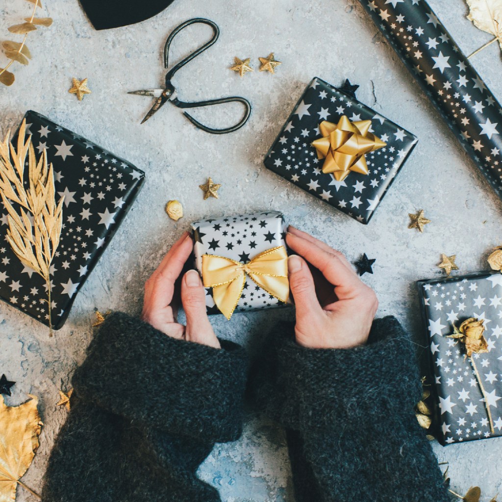 Person wrapping gifts with bows