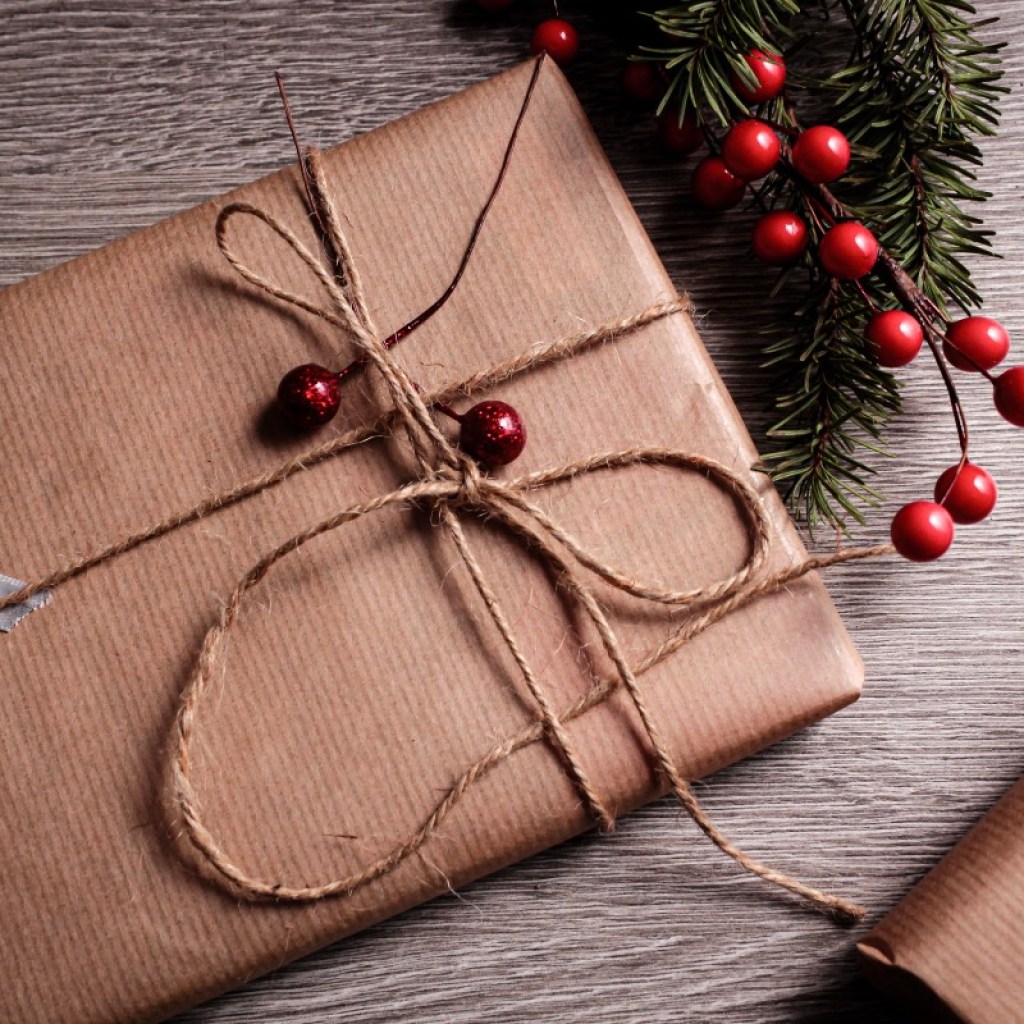 Christmas gift wrapped in brown paper with cranberries