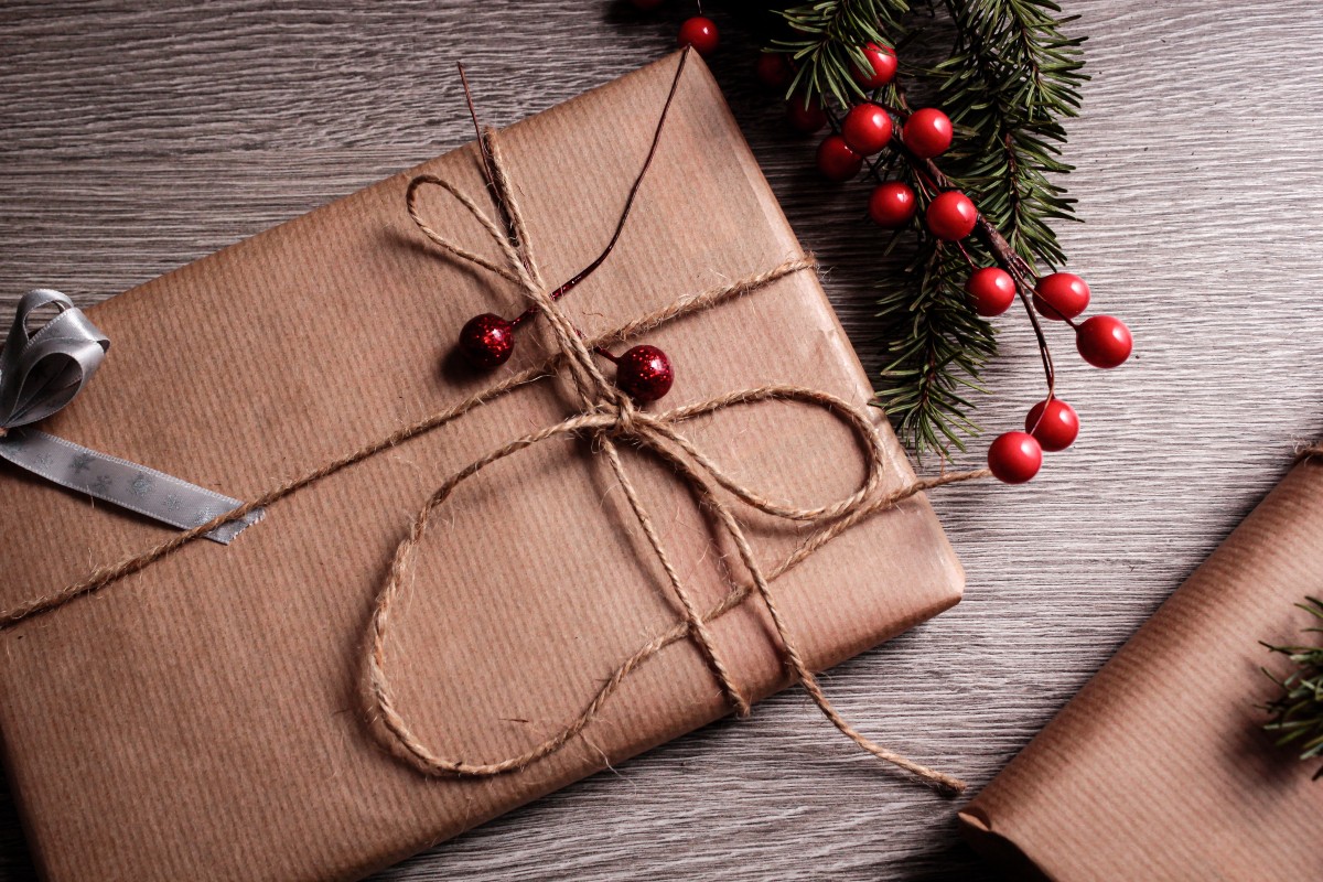Christmas gift wrapped in brown paper with cranberries