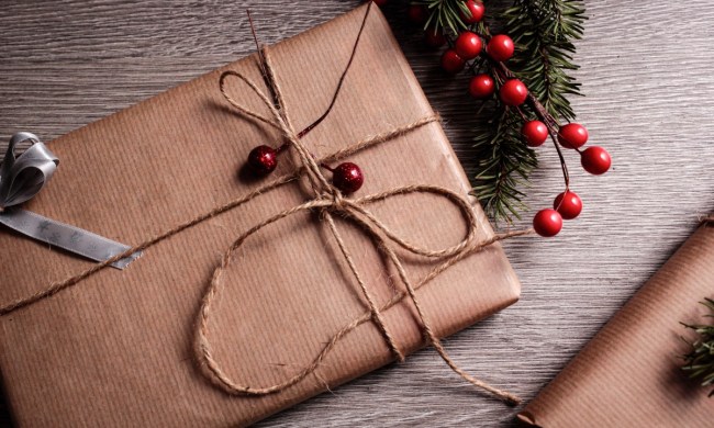 Christmas gift wrapped in brown paper with cranberries