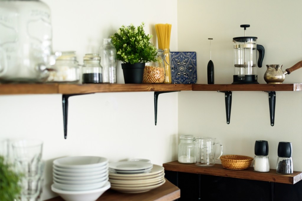 Open shelving with coffee maker and dishes in small kitchen