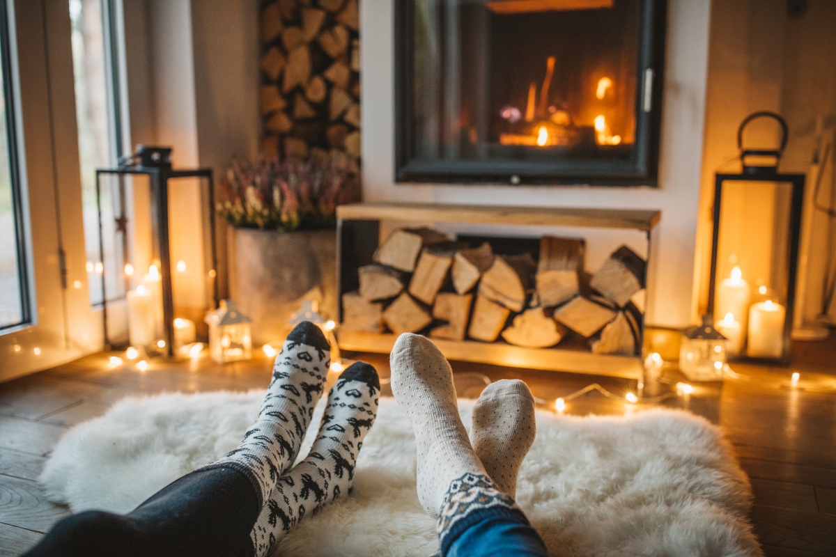 people cozying up to the fire by a fireplace in a living room