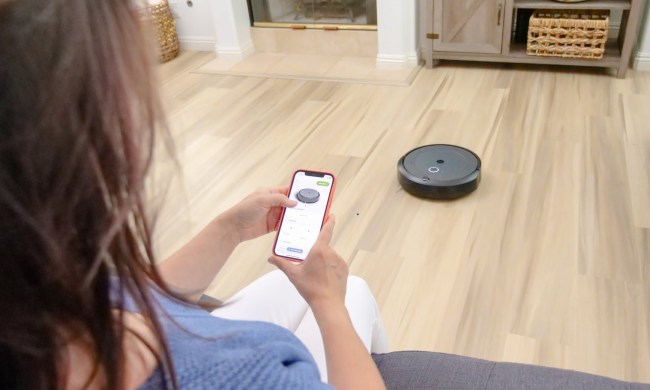 woman using phone to control robot vacuum