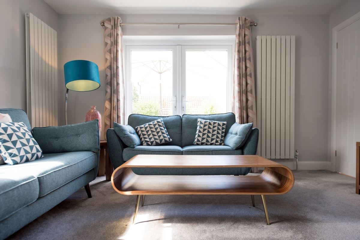 retro living room with curved coffee table and blue sofas
