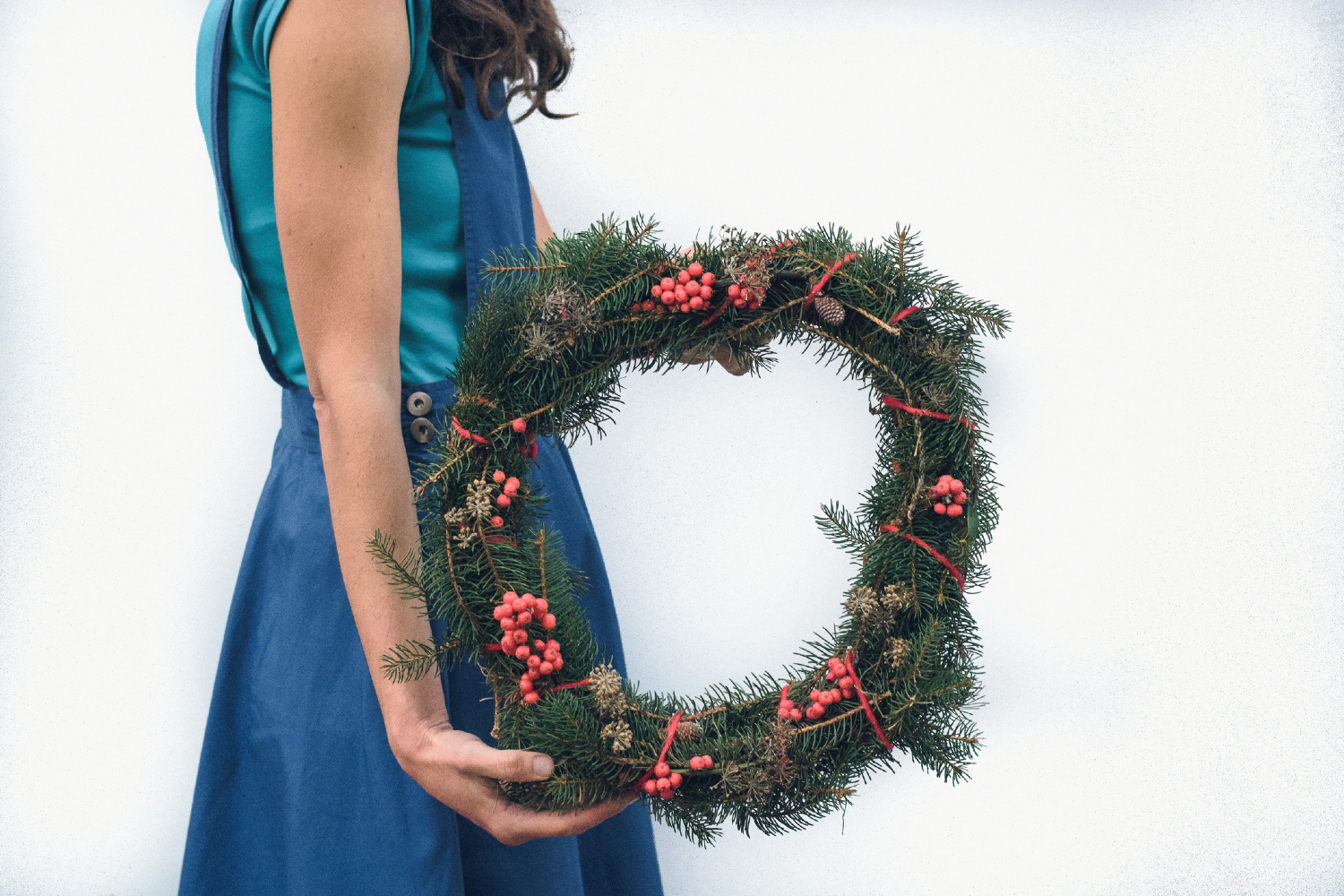 Woman holding Christmas wreath made of real trees