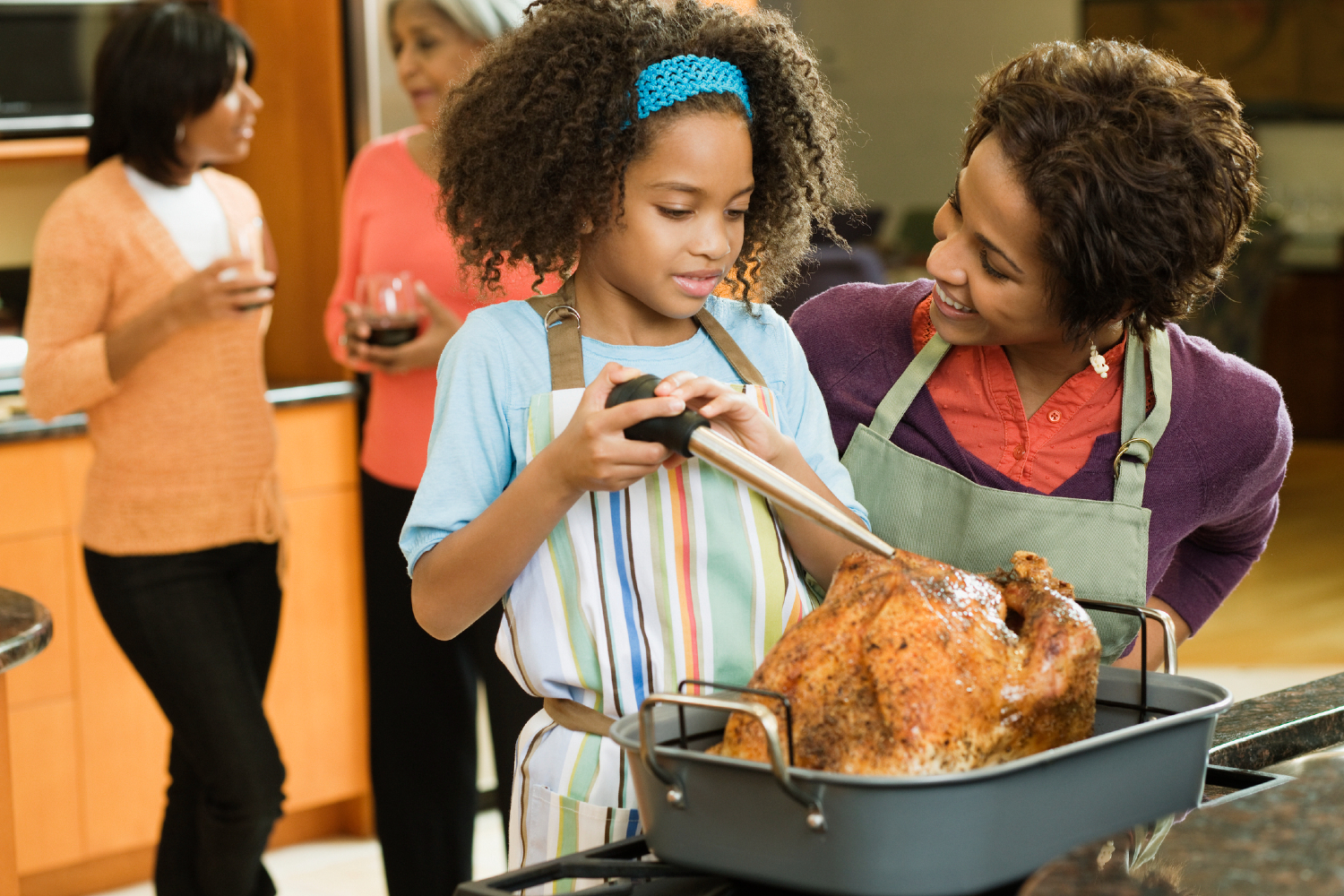 Woman and child basting Thanksgiving turkey.