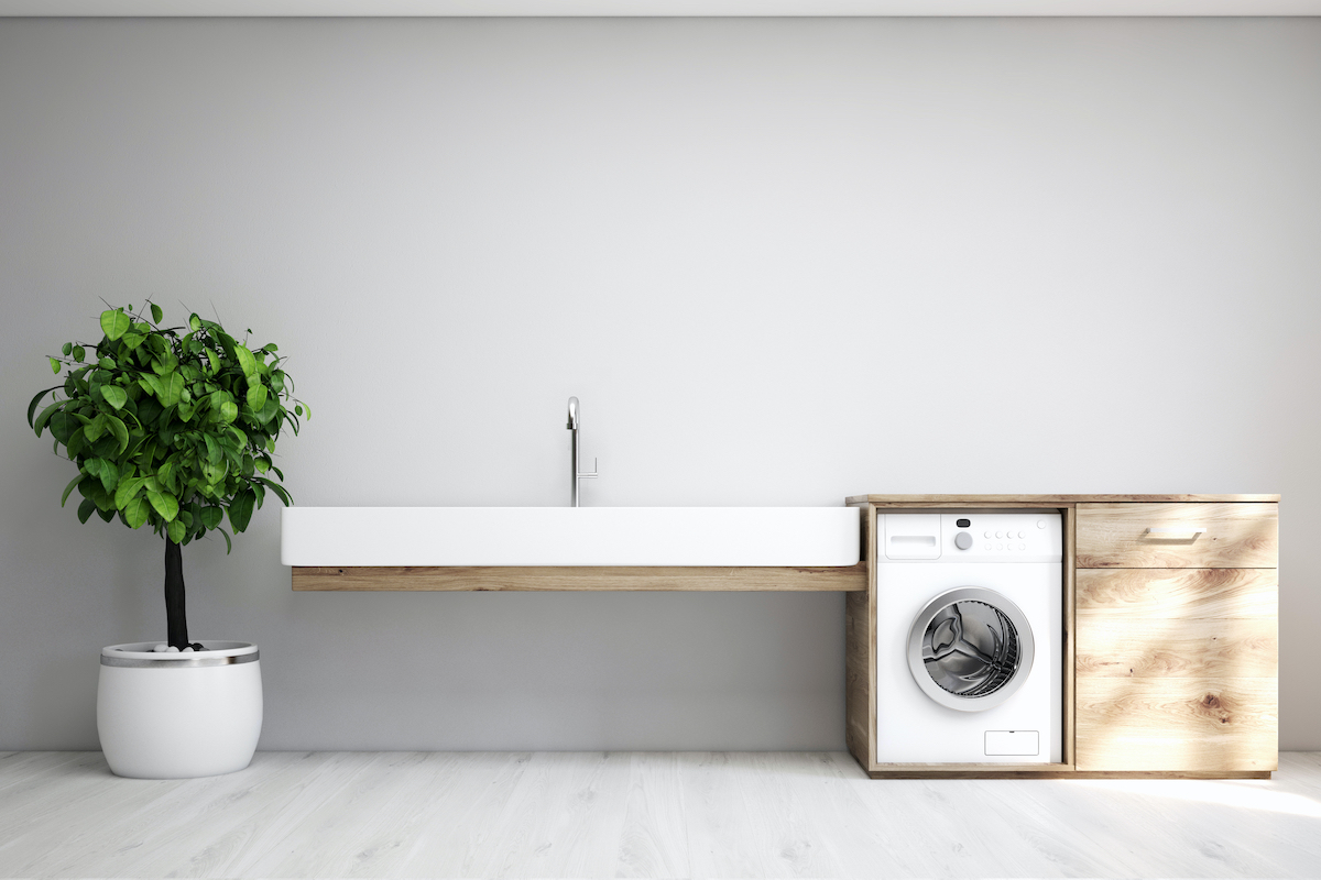 Gray laundry room interior with a sink and washing machine