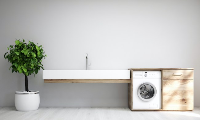 Gray laundry room interior with a sink and washing machine