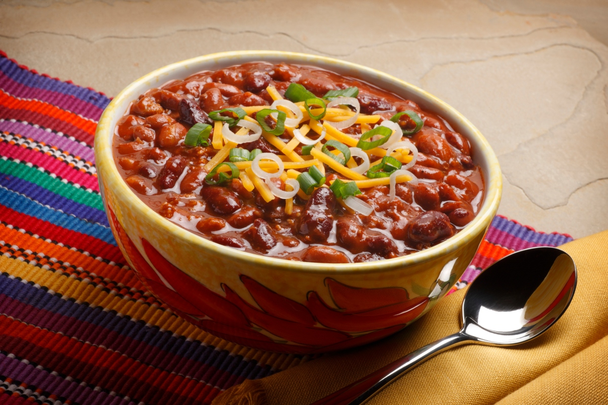 bowl of chili with cheese and onion toppings