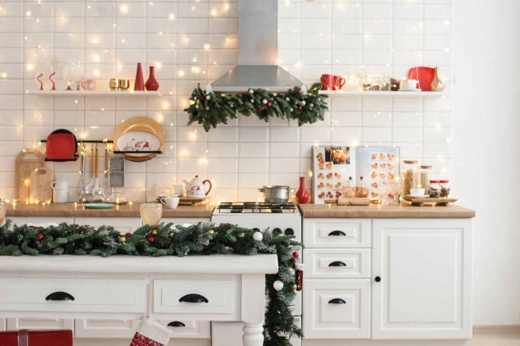 Kitchen with red and green winter color palette, garland, and fairy lights